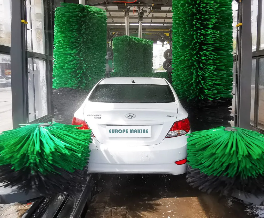 A white car between green wash brushes in a Europe Makine tunnel