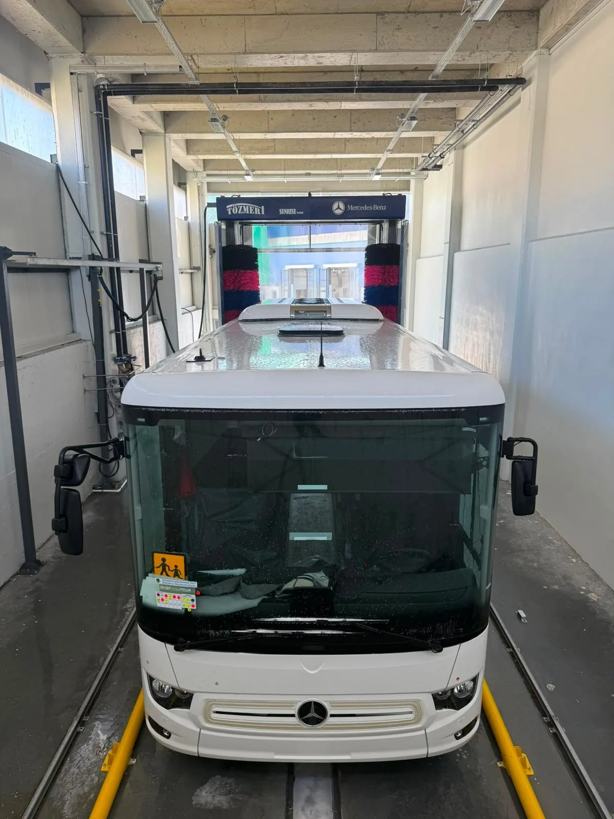 A white coach entering a SUNRISE inside a wash hall
